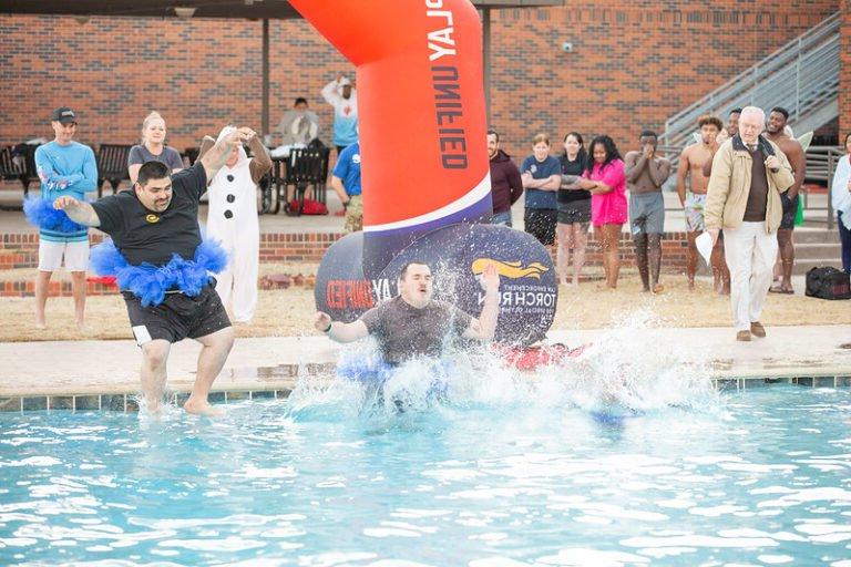 Participants jump into the pool during the 2023 Polar Plunge.
